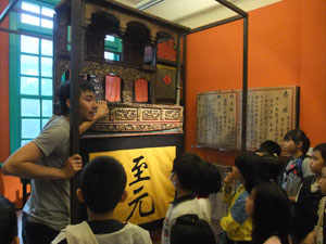 A volunteer guides second-graders through the Lin Liu-hsin Puppet Theatre Museum. (Photo Courtesy of Taipei City